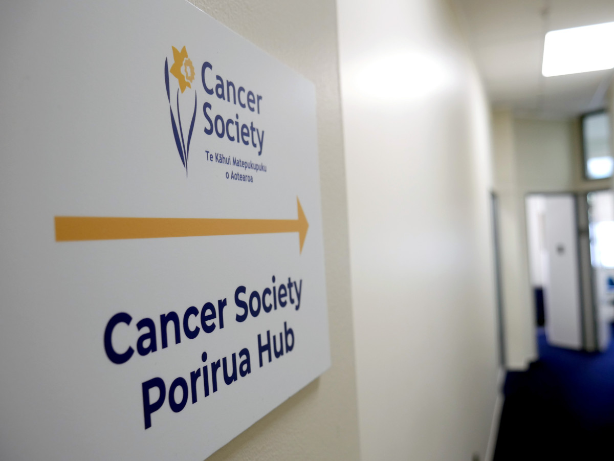 Cancer Society Porirua Hub sign with office in background.